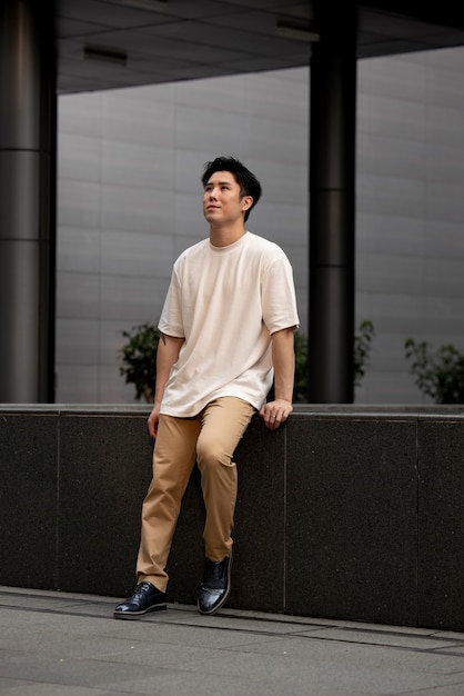 Free photo portrait of handsome asian man posing outdoors in the city