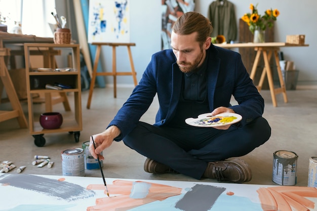 Free photo portrait of handsome bearded man in an art studio