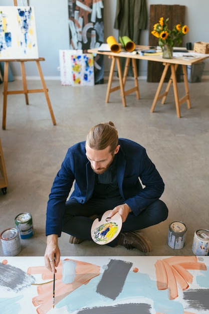 Free Photo portrait of handsome bearded man in an art studio