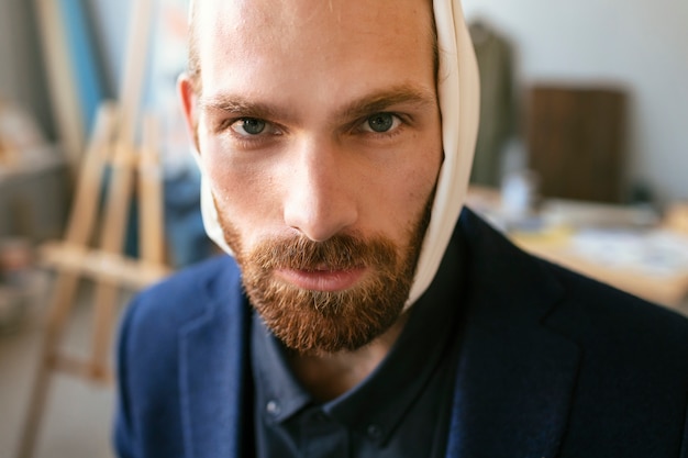 Free photo portrait of handsome bearded man with ear bandage in an art studio