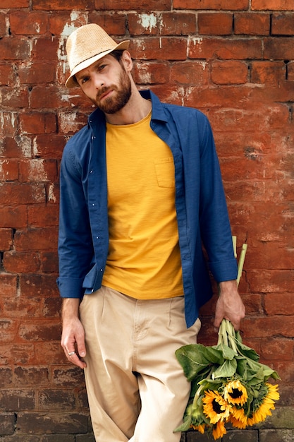 Free Photo portrait of handsome bearded man with sunflowers