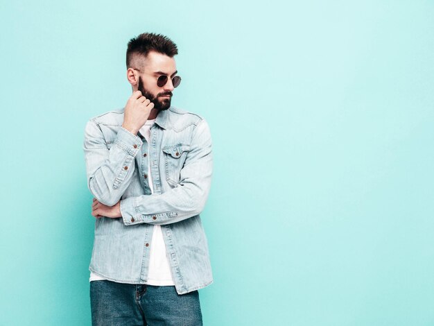 Portrait of handsome confident model Sexy stylish man Fashion hipster male posing near wall in studio Isolated