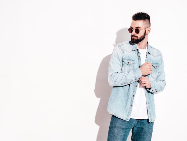 Portrait of handsome confident model Sexy stylish man Fashion hipster male posing near wall in studio Isolated