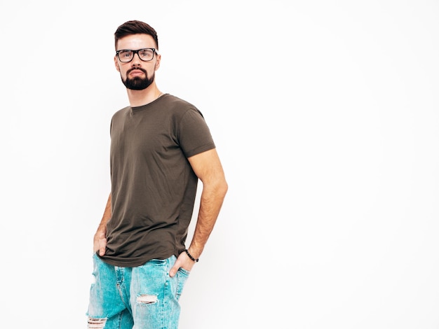 Portrait of handsome confident stylish hipster lambersexual modelMan dressed in Tshirt and jeans Fashion male isolated on white wall in studio