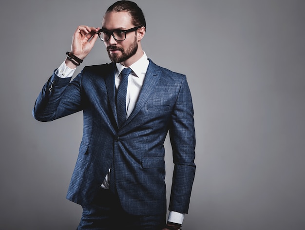 Free photo portrait of handsome fashion businessman model dressed in elegant blue suit with glasses