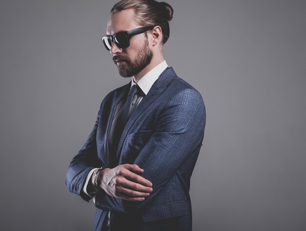 portrait of handsome fashion businessman  model dressed in elegant blue suit with sunglasses