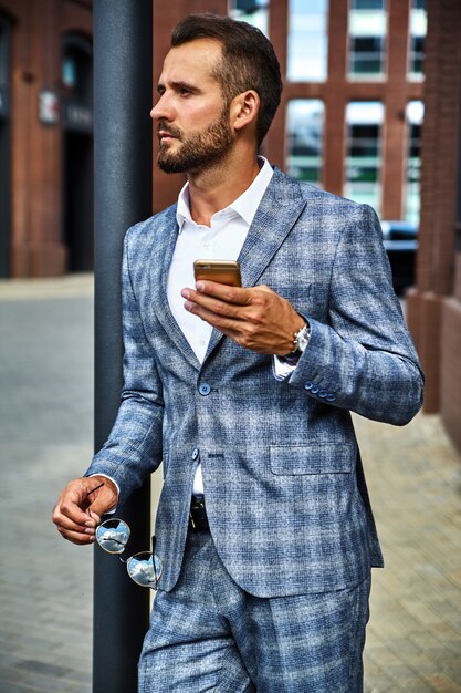 Portrait of handsome fashion businessman model dressed in elegant checkered suit