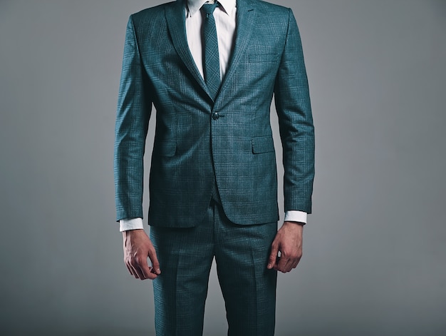 portrait of handsome fashion stylish  businessman model dressed in elegant green suit posing on gray background in studio