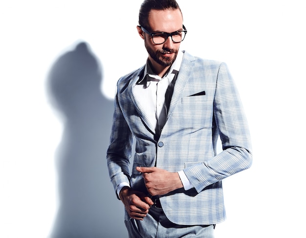 portrait of handsome fashion stylish hipster businessman model dressed in elegant light blue suit in glasses on white