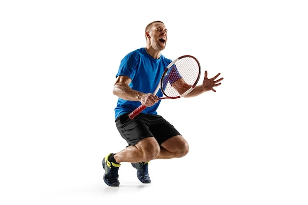 Portrait of a handsome male tennis player celebrating his success isolated on a white  wall. Human emotions, winner, sport, victory concept