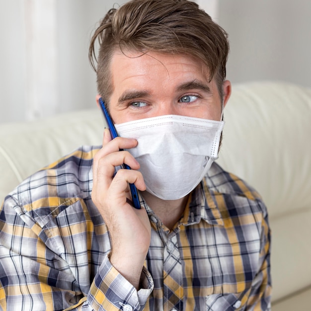 Free photo portrait of handsome male with face mask talking on the phone