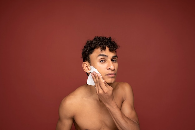 Portrait of a handsome man cleaning his face with a tissue