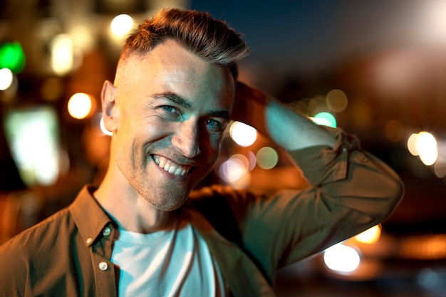 Portrait of handsome man at night in the city lights