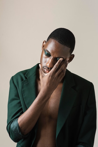 Portrait of handsome man posing in blazer and wearing make-up