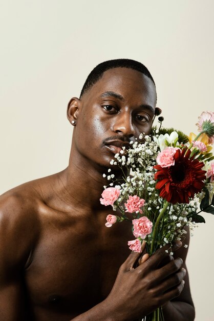 Portrait of handsome man posing with bouquet of flowers