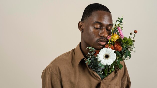 Portrait of handsome man posing with bouquet of flowers