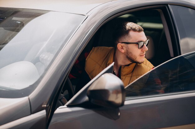 Portrait of handsome man sitting in car