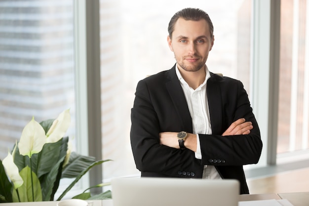 Free photo portrait of handsome smiling businessman in office