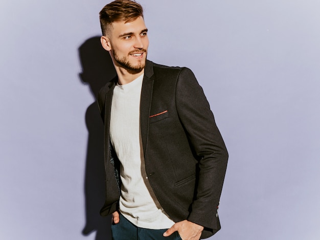 Portrait of handsome smiling hipster  businessman model wearing casual black suit.