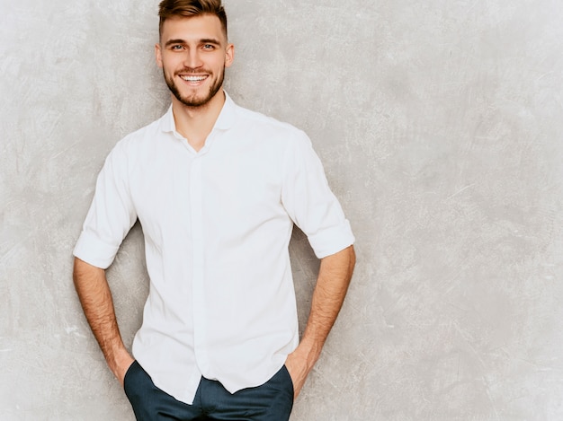 Free photo portrait of handsome smiling hipster  businessman model wearing casual summer white shirt.