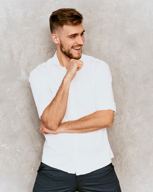 Portrait of handsome smiling hipster  businessman model wearing casual summer white shirt. 