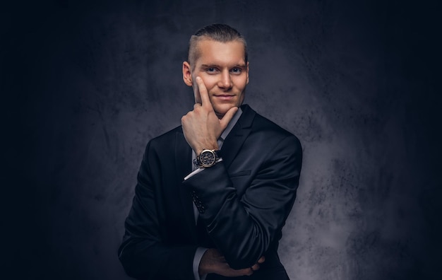 Free photo a portrait of handsome, smiling stylish businessman over a dark background.