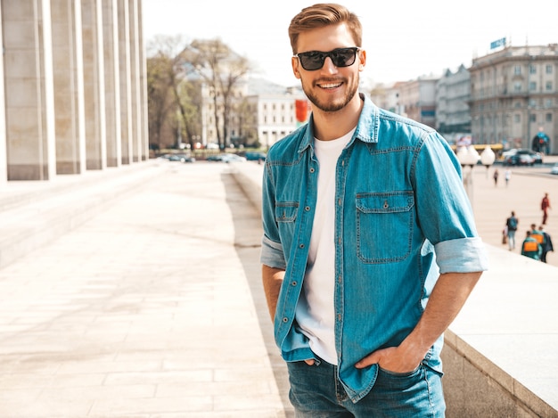 Portrait of handsome smiling stylish hipster lumbersexual businessman model. Man dressed in jeans jacket clothes. 