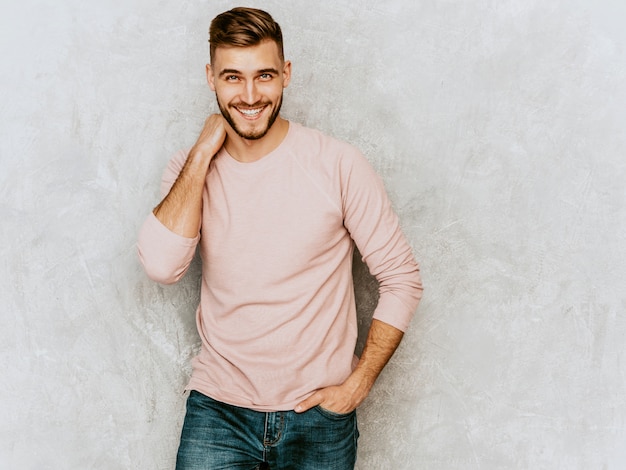 Portrait of handsome smiling young man model wearing casual summer pink clothes. Fashion stylish man posing