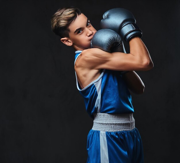 Free photo portrait of a handsome young boxer during boxing exercises, focused on process with serious concentrated facial.