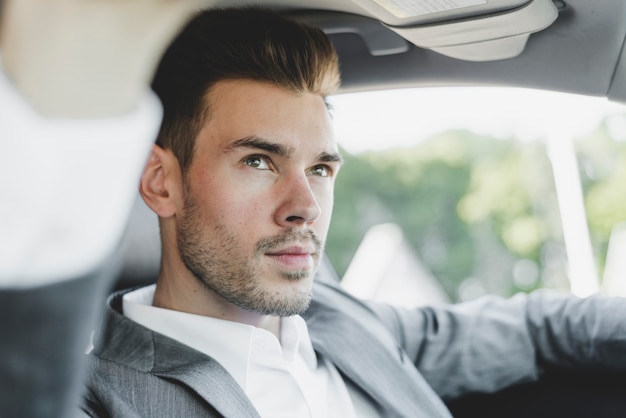 Free photo portrait of handsome young businessman in the car