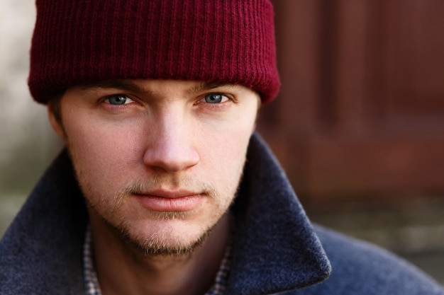 Free photo portrait of handsome young man in red hat posing outside