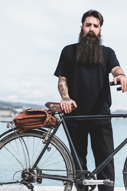 Portrait of a handsome young man with his bicycle