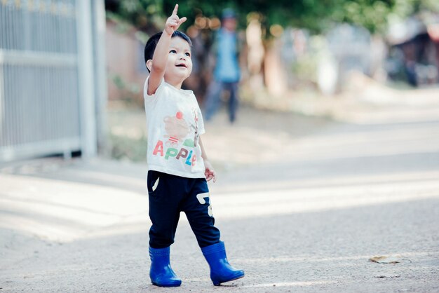 Portrait of happy Asian boy outdoors in image with copy space