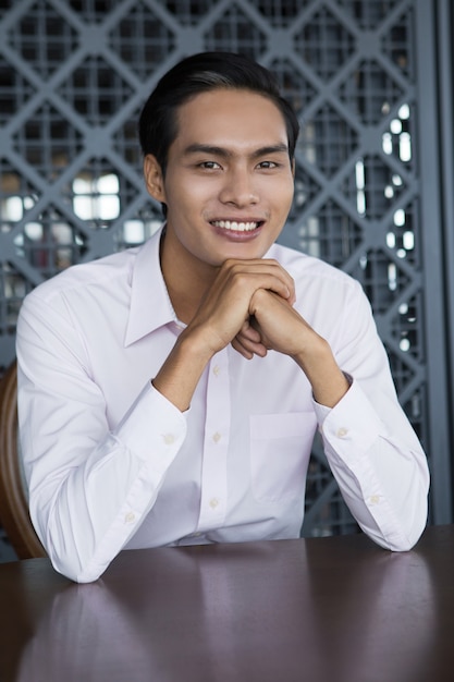 Free photo portrait of happy asian man sitting in restaurant