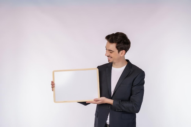 Free photo portrait of happy businessman showing blank signboard on isolated white background