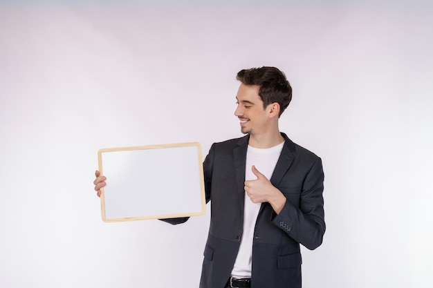 Free photo portrait of happy businessman showing blank signboard on isolated white background