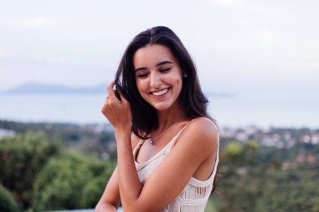 Portrait of happy caucasian calm romantic woman in casual look with long hair wearing earings and necklace on background amazing beautiful view on green mountains