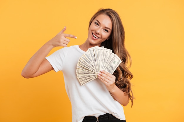 Portrait of a happy cheerful girl pointing finger