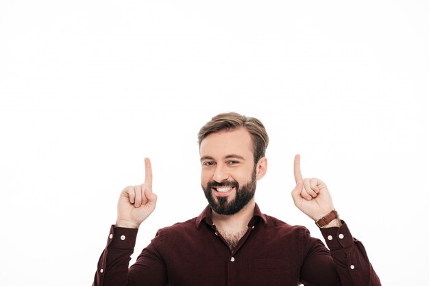 Portrait of a happy cheerful man pointing two fingers up