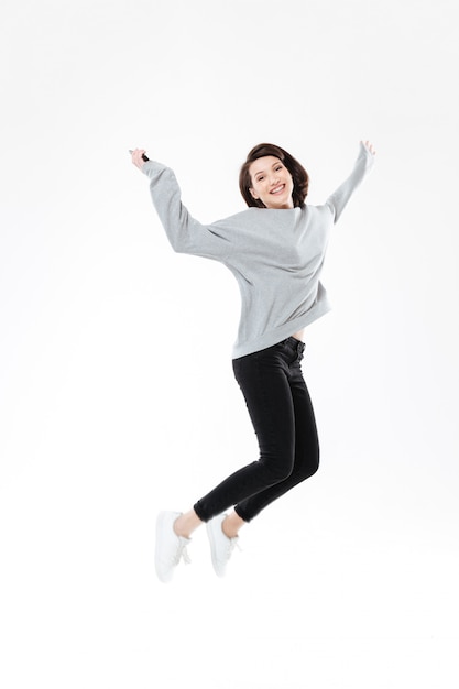 Free Photo portrait of a happy cheerful woman jumping and celebrating success