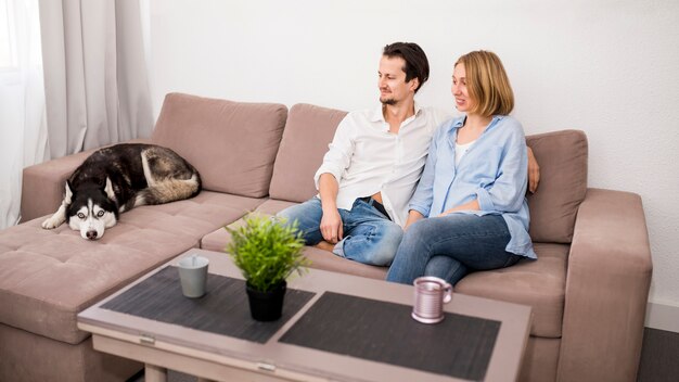 Portrait of happy couple at home with dog