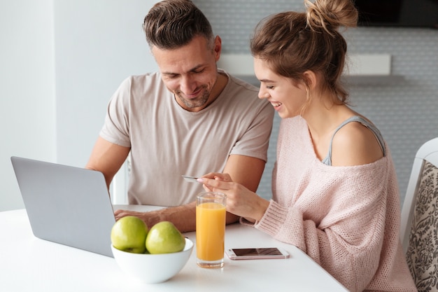 Portrait of a happy couple shopping online with laptop