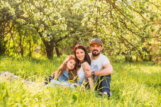 Portrait of happy couple sitting on green grass in the park