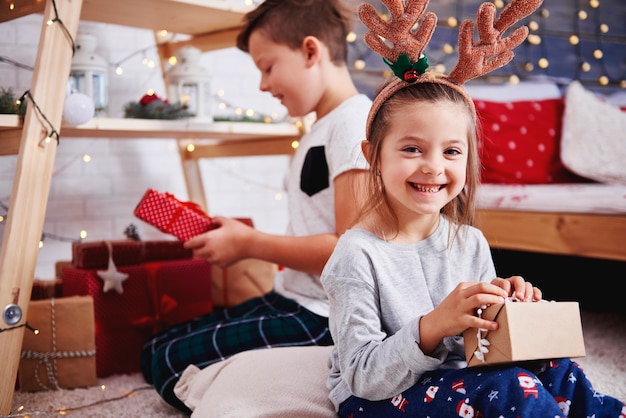 Portrait of happy girl opening christmas present