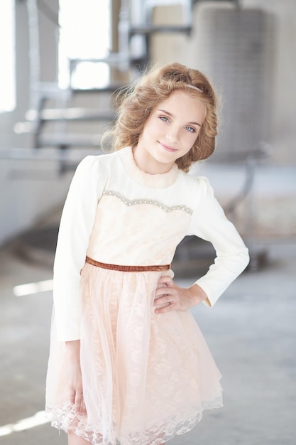 Free photo portrait of a happy little girl model with charming smile posing in a studio.