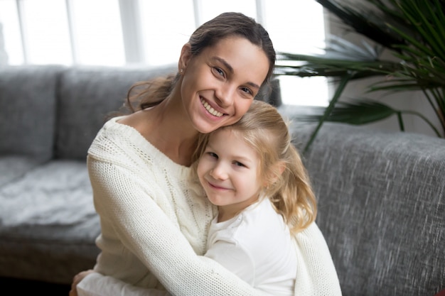 Free Photo portrait of happy loving single mother hugging cute little daughter