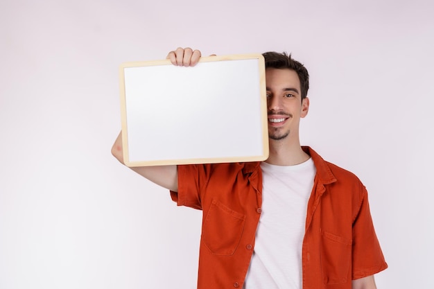 Free photo portrait of happy man showing blank signboard on isolated white background