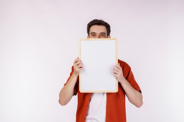 Free photo portrait of happy man showing blank signboard on isolated white background