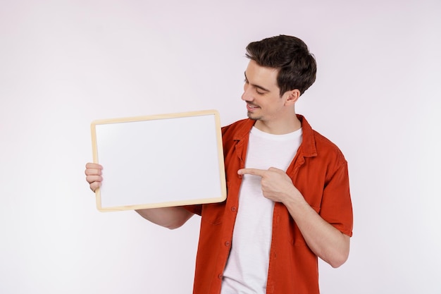 Free photo portrait of happy man showing blank signboard on isolated white background