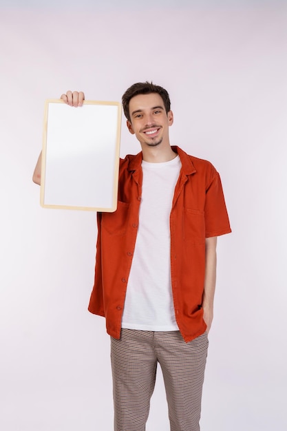 Free photo portrait of happy man showing blank signboard on isolated white background